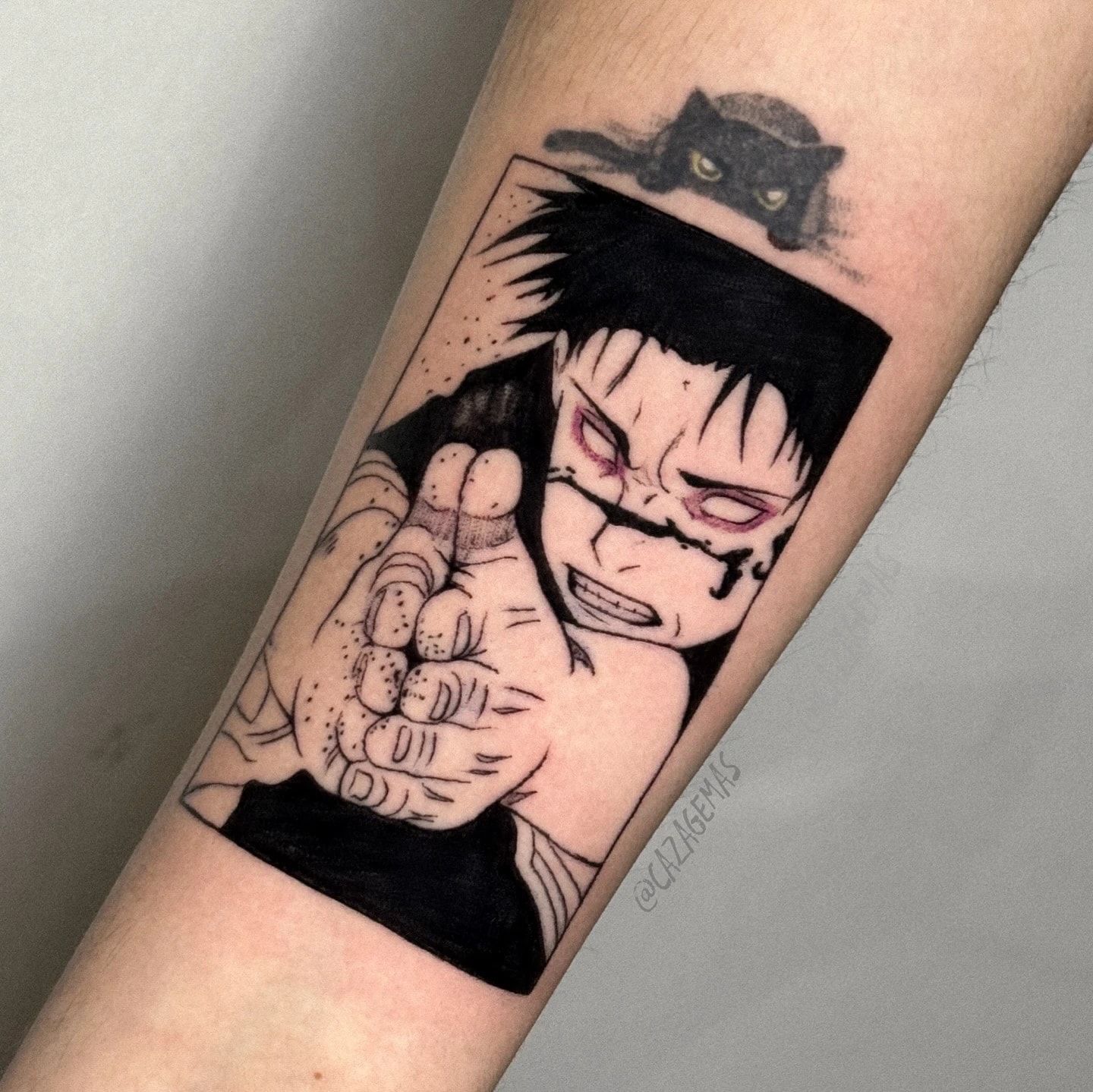 Tatuaje de un panel de manga en negro de un personaje con una cicatriz en el rostro cerrando el puño, con un pequeño gato negro encima